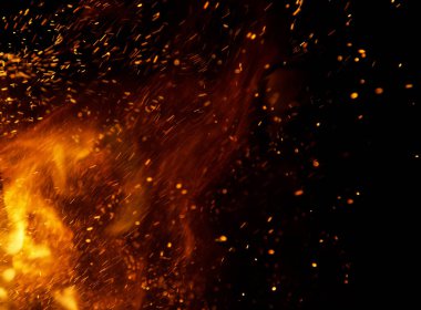 Siyah arkaplanda kıvılcımlar saçan ateş alevleri