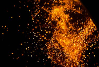 Siyah arkaplanda kıvılcımlar saçan ateş alevleri