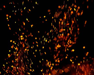 Siyah arkaplanda kıvılcımlar saçan bir ateş alevi