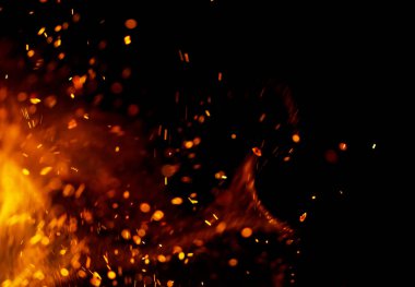 Flame of fire with sparks on a black background clipart