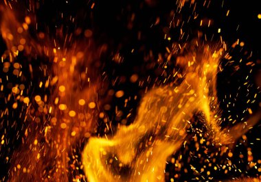 Siyah arkaplanda kıvılcımlar saçan bir ateş alevi