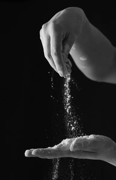 黒い背景に小麦粉の手 — ストック写真