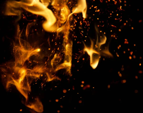 Siyah arkaplanda kıvılcımlar saçan ateş alevleri