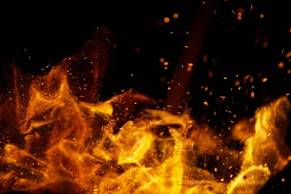 Siyah arkaplanda kıvılcımlar saçan ateş alevleri