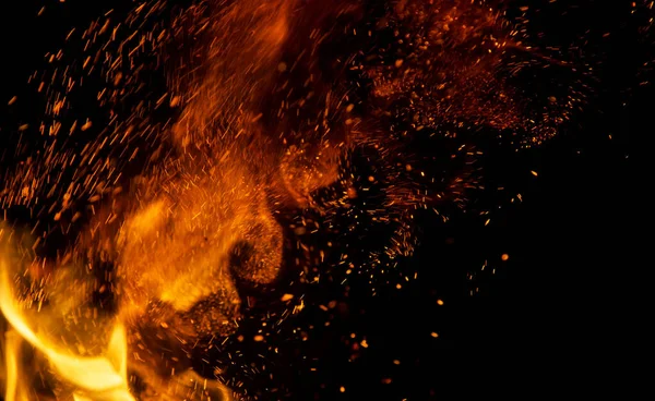 Siyah arkaplanda kıvılcımlar saçan ateş alevleri