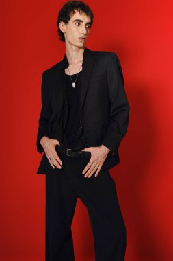 Yakışıklı bir adam zarafetini ve tarzını özel dikim siyah bir takım elbiseyle sergiliyor..