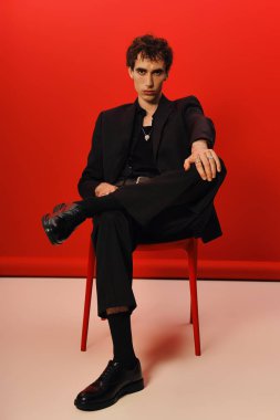 Şık bir centilmen kendine güvenerek oturur ve tarzıyla gösteriş yapar..