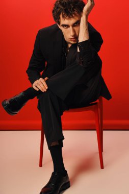 Zarif giyinmiş yakışıklı bir adam şık bir yerde oturur, kendine güveni tamdır..