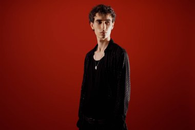 Yakışıklı bir adam zarif bir elbise içinde, özgüven ile cesur bir moda ifadesi yapıyor.