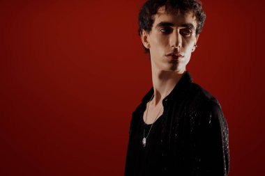 Yakışıklı adam kusursuz bir moda anlayışı sergiliyor. Parlak siyah kıyafetler içinde, karizma saçıyor..