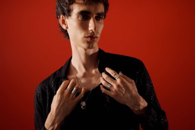 Şık giyinmiş yakışıklı adam kendine güvenen, havalı ve entelektüel bir poz veriyor..