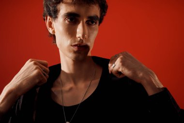 Yakışıklı bir birey, sofistike giyinmiş, kendine güveni ve tarzıyla cazibesini yayar..