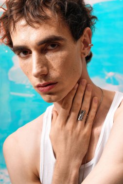 Kendine güveni olan, modaya uygun kıyafetleri olan, sanatsal bir ortamda poz veren bir adam..