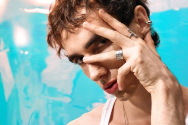 Yakışıklı bir adam şık aksesuarlarıyla kendine güvenerek poz verir, şık bir karizma yayar..