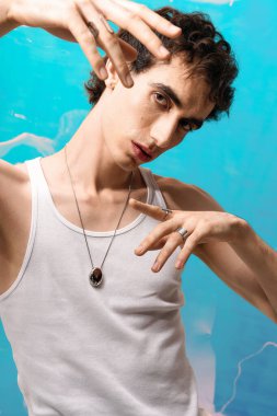 Zarif giyinmiş yakışıklı bir adam renkli bir arka plana yaratıcı bir şekilde poz veriyor..