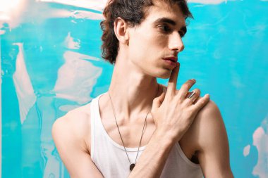 Şık bir adam kendine güvenerek poz verir, zarif kıyafetinin ve büyüleyici varlığının altını çizer..