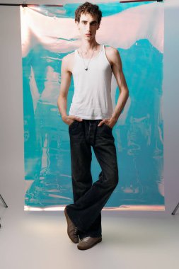 Yakışıklı bir adam şık giyinip, canlı bir arka plana karşı moda sergiliyor..