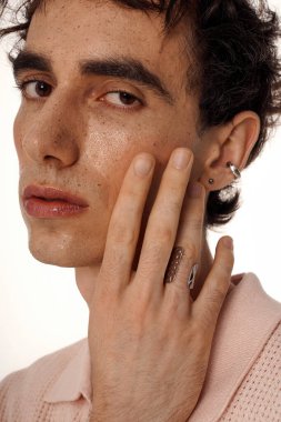 Çekici bir genç adam zarif tarzı ve düşünceli duruşuyla sofistike bir görünüm sergiliyor..