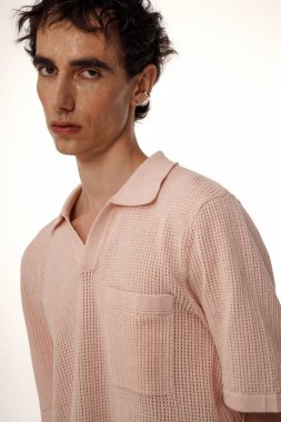 Yumuşak pembe örgü içinde şık bir figür modern zarafet ve kendine güven yayar..