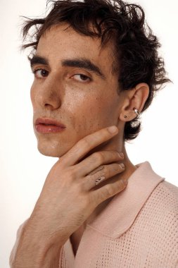 Yakışıklı bir adam zarif giysileriyle tarzını sergiliyor, benzersiz aksesuarlarını vurguluyor..