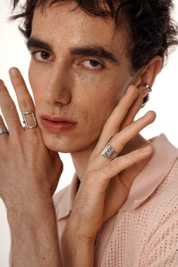 Yakışıklı bir adam zarif yüzükler ve sakin bir ifadeyle eşsiz tarzını sergiliyor..