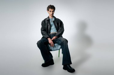 Şık bir birey, otururken ve zamansız bir şekilde somutlaşırken modern zarafet sergiler..