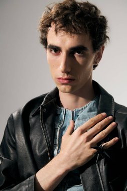 Kendine güvenen bir adam şık bir şekilde poz verir. Benzersiz bir yetenek ve cesur bir ifadeyle..