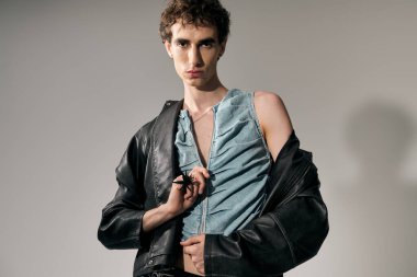 Şık bir adam kendine güvenerek poz verir, kenar stili ile zarafeti kolayca birleştirir..