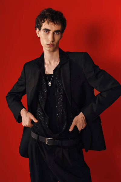 Стильный человек уверенно позирует в элегантной одежде, подчеркивая его чувство моды и харизму.