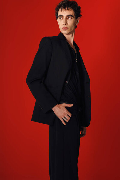 Модный человек в элегантной одежде уверенно позирует, создавая завораживающее зрелище.