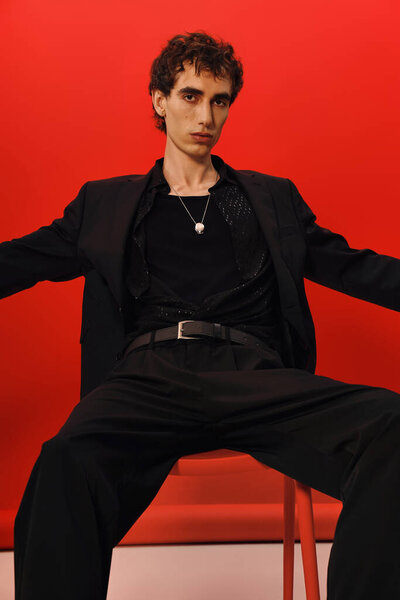 Красивый человек демонстрирует современную моду, смело позируя в шикарной обстановке.