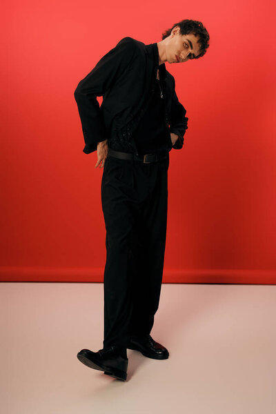 Handsome gentleman exudes charm while striking a fashionable pose on a smooth floor.