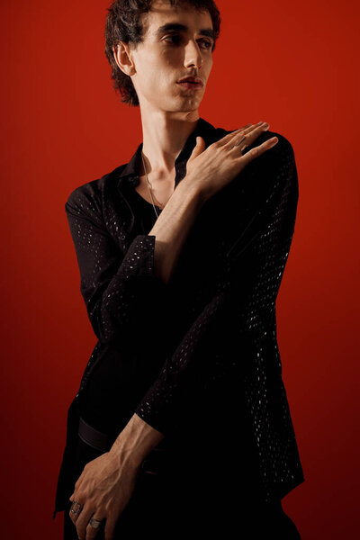 Красивый мужчина в элегантной одежде оживляет композицию своим присутствием и выразительной позицией.