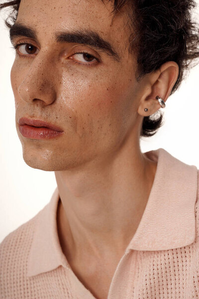 A stylish man in elegant clothes exudes confidence against a neutral background.