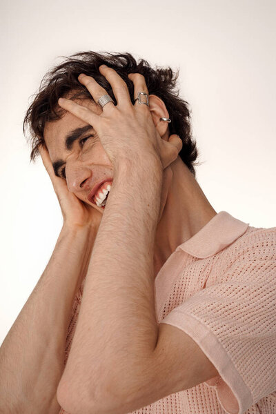 A stylish man displays joy and despair in elegant attire.