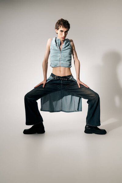 Уверенный джентльмен выставляет напоказ современный наряд с художественной позой в шикарном помещении.