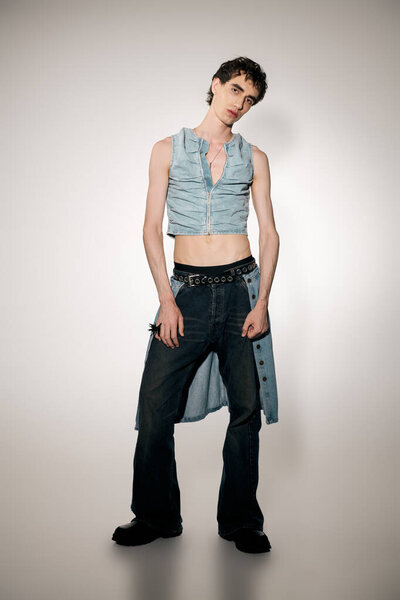 A stylish man in an elegant denim outfit stands confidently, exuding charm and fashion sense.