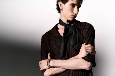 Stylish young man poses confidently with a striking look and trendy accessories.