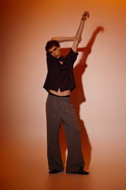 A handsome young man poses in stylish attire, highlighting contemporary fashion trends and charisma.