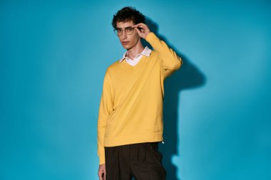 Handsome young man poses confidently in fashionable attire, embodying contemporary style and charm.