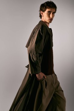 Handsome young man showcases unique fashion sense in a creative studio environment.