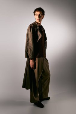 Handsome young man poses confidently in a stylish outfit, highlighting contemporary fashion design.