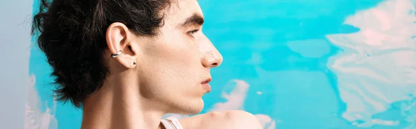 Очаровательный мужчина в элегантной одежде вдумчиво смотрит на яркий фон. — стоковое фото