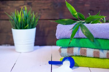 Ahşap arka planda yıkanmış renkli havlular. Evi temizliyorum..