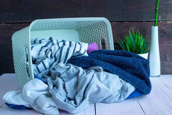 Basket with dirty Laundry on a wooden background. House cleaning — Stock Photo, Image