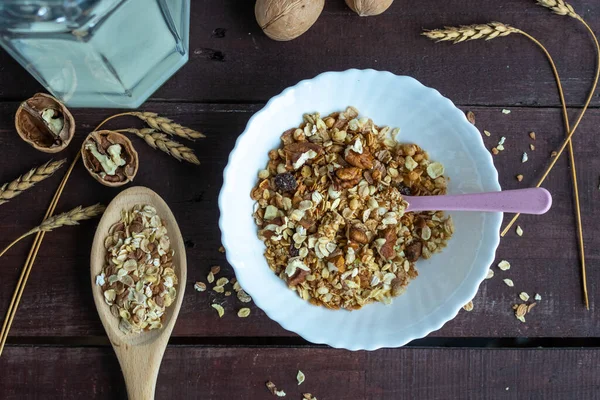 Useful muesli with nuts in a plate on a wooden table. Healthy lifestyle — Stock Photo, Image