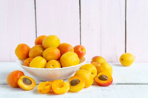 Frische Aprikosen liegen in einem Teller auf einem hölzernen Hintergrund. Frische Ernte — Stockfoto
