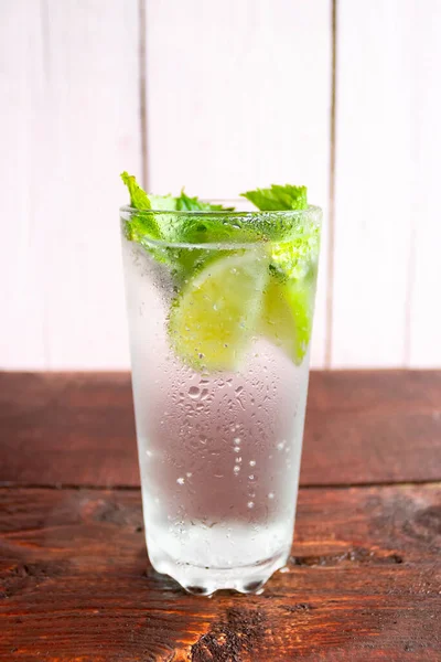 A glass of fresh Mojito. Lime and mint. On a wooden background — Stock Photo, Image