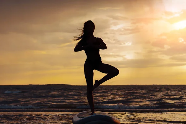 Genç Seksi Sörfçü Kadın Gün Batımında Yemek Tahtasında Meditasyon Yapıyor — Stok fotoğraf