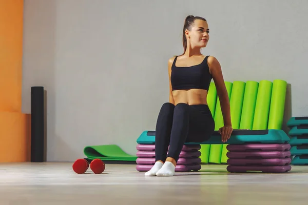 Genç beyaz kadın fitness stüdyosundaki bir platformda şınav çekiyor. Sağlıklı yaşam tarzı kavramı. 